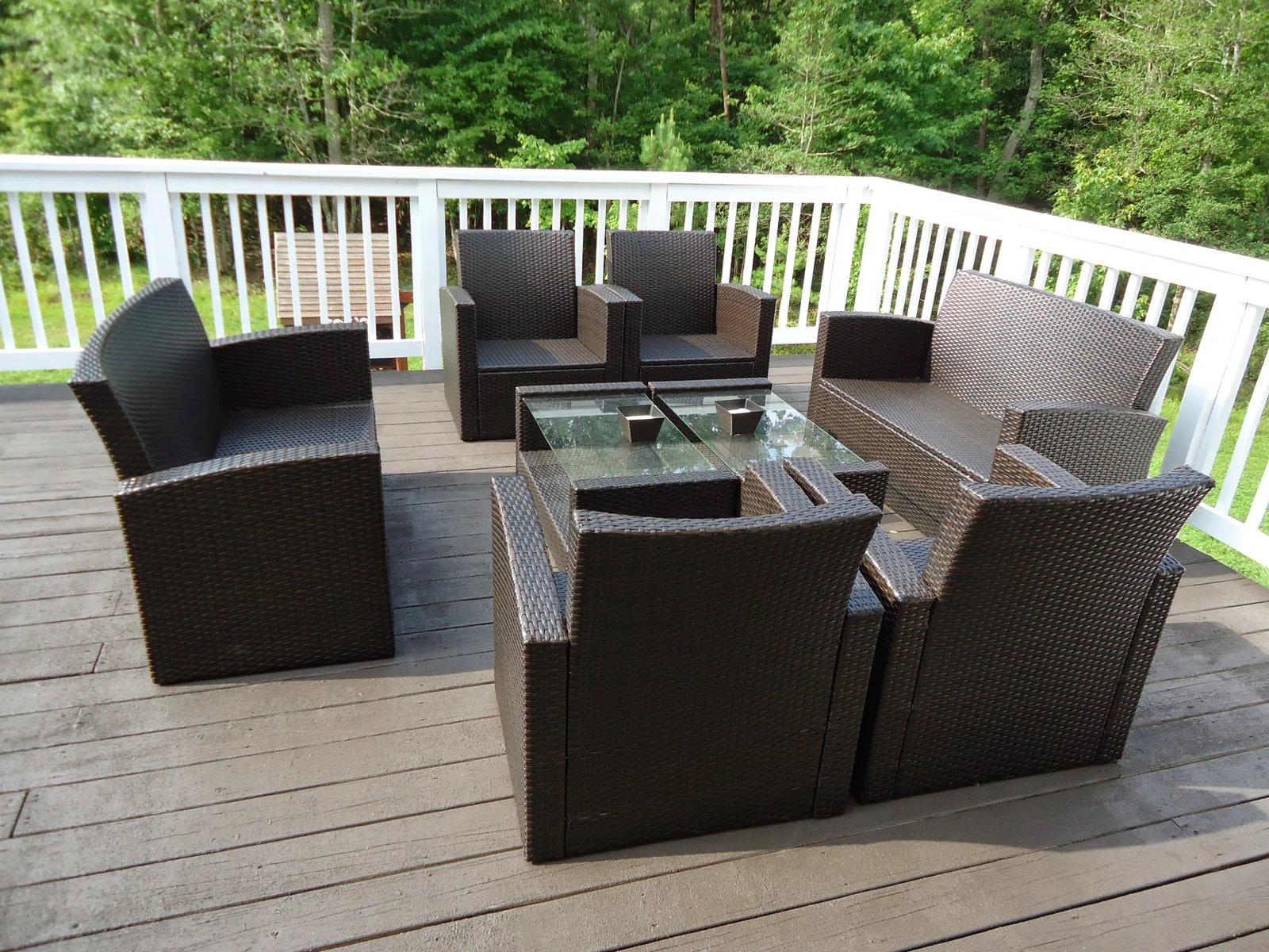 Gray composite-style deck boards with white railings and wicker seating