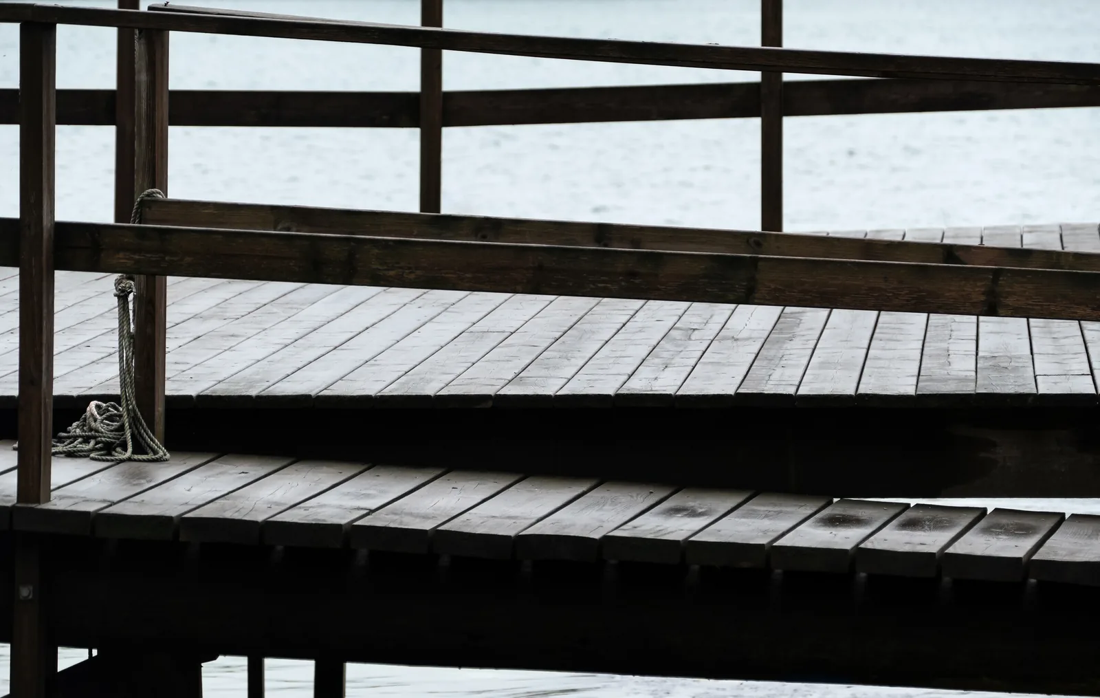 Dark-stained deck platform with a wood railing and a step-down level