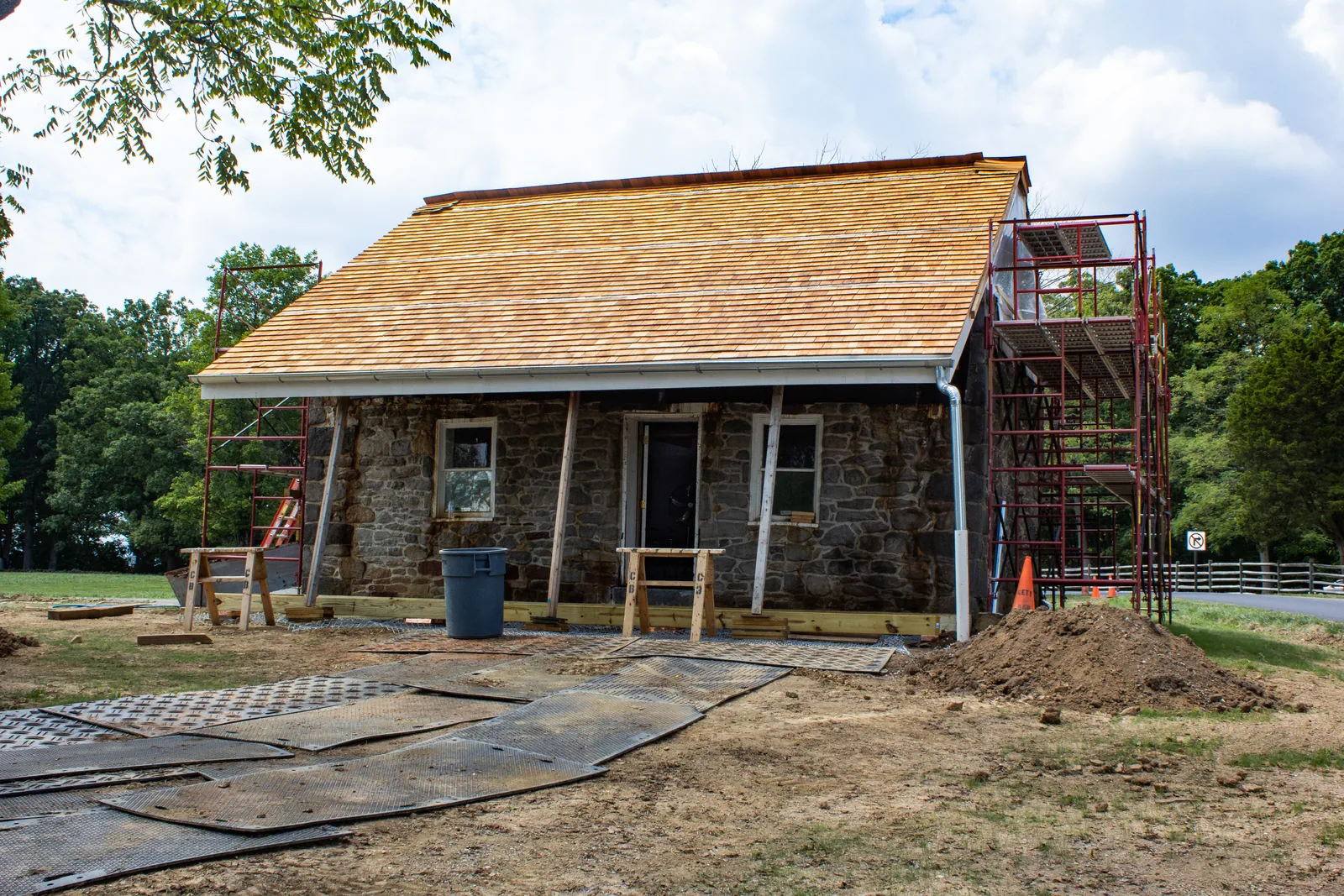 Porch mid-rebuild with temporary shoring posts and scaffolding supporting the roof